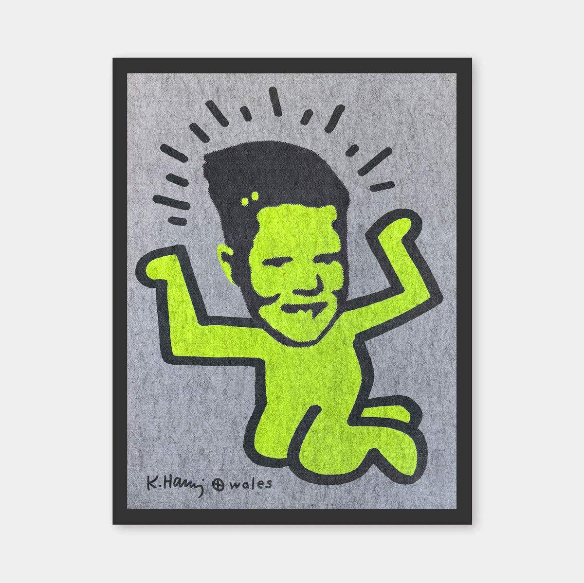 A framed art print featuring a stylized neon green cartoon figure with black outlines on a textured gray background, signed K.Haring and Wales.