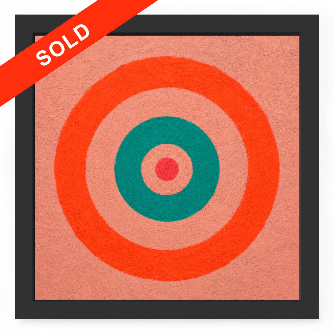 A square framed art print featuring concentric target-like circles in coral orange, teal, and pink on a peach background, with a red diagonal 'SOLD' banner across the top left corner.