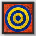 Framed square wall art featuring concentric target-like circles in blue and yellow on a textured orange-red background, shown against a light gray wall.